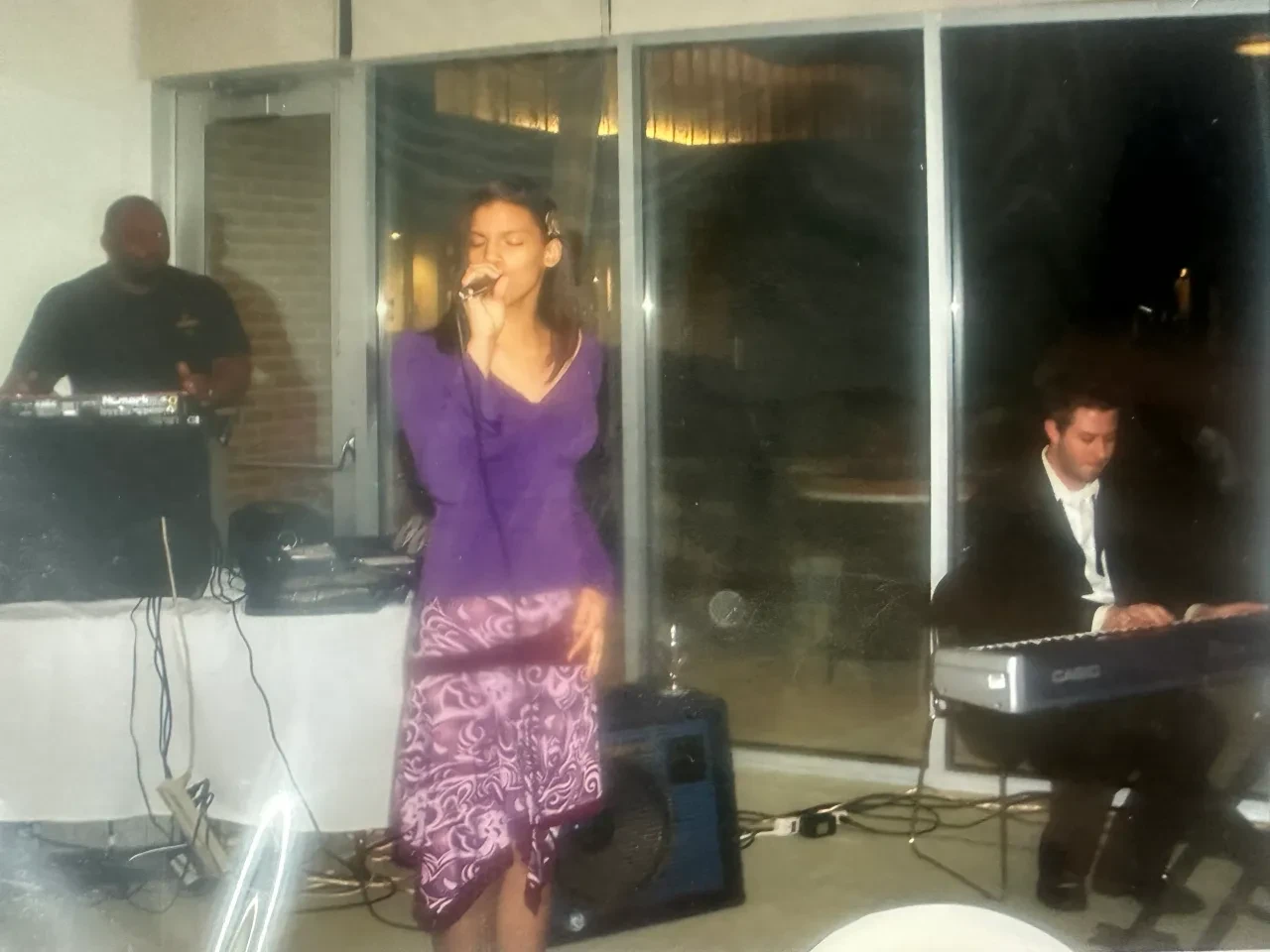 Chloe McFadden singing in a purple dress at an evening event