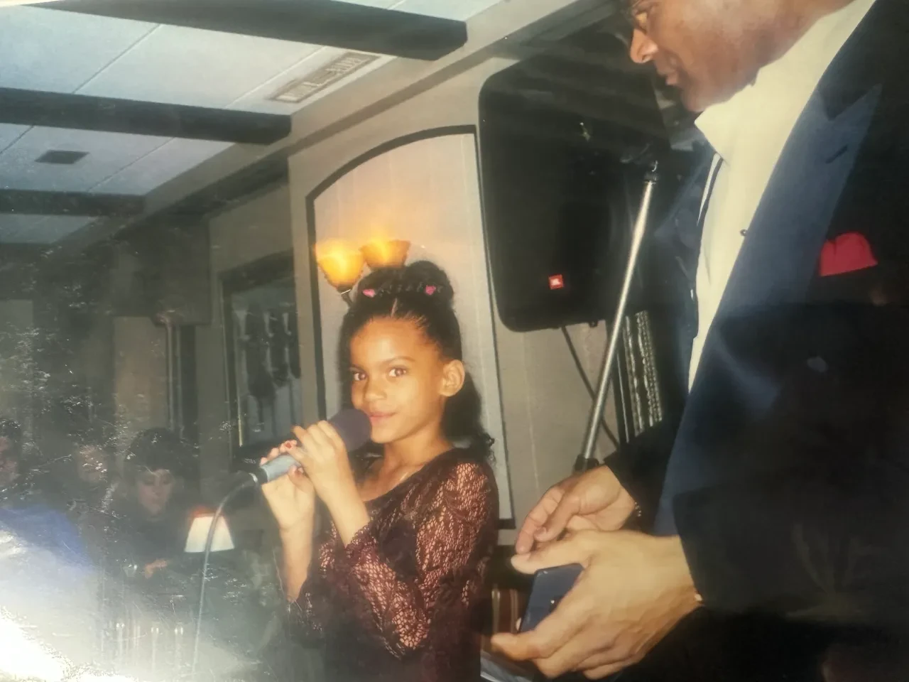 Young Chloe McFadden holding a microphone at an early performance